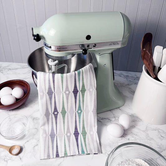 KitchenAid stand mixer with a towel draped over it on a kitchen counter.
