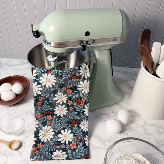 Kitchen mixer with a floral towel draped over it on a kitchen counter.