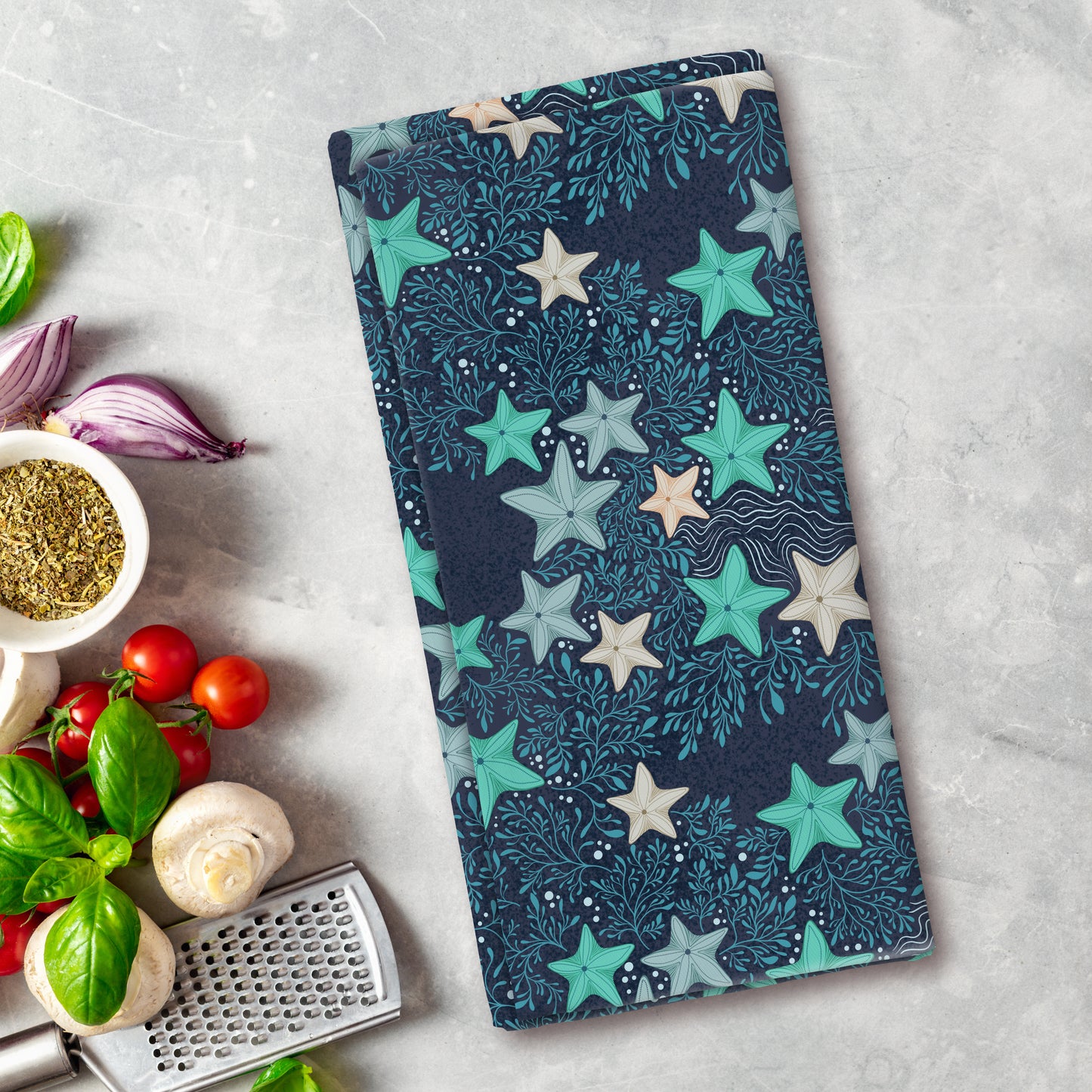 Colorful star-patterned cutting board on a kitchen counter with vegetables and a grater.