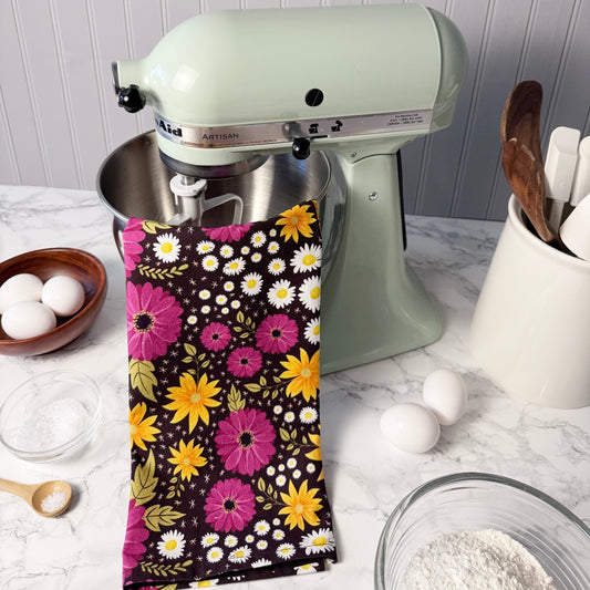Kitchen mixer with a floral towel draped over it on a kitchen counter.