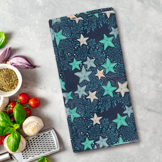 Colorful star-patterned cutting board on a kitchen counter with vegetables and a grater.