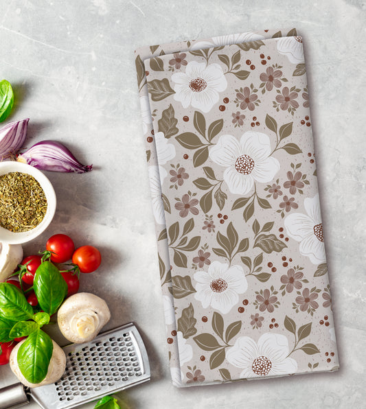 Floral patterned towel on a kitchen counter with vegetables and a grater.
